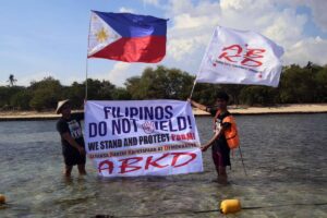 Fisherfolk from Zambales, along with Alyansa Bantay Kapayapaan at Demokrasya, wave a Philippine flag during a fluvial parade in the West Philippine Sea in Candelaria, Zambales, on Saturday, May 11, 2024, to express their condemnation of the harassment by the Chinese Coast Guard of Filipino fishermen. PHOTOS BY ISMAEL DE JUAN