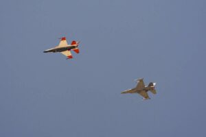An AI-enabled Air Force F-16 fighter jet (left) flies next to an adversary F-16, as both aircraft race within 1,000 feet of each other, trying to force their opponent into vulnerable positions, on Thursday, May 2, 2024, above Edwards Air Force Base, California. AP PHOTO