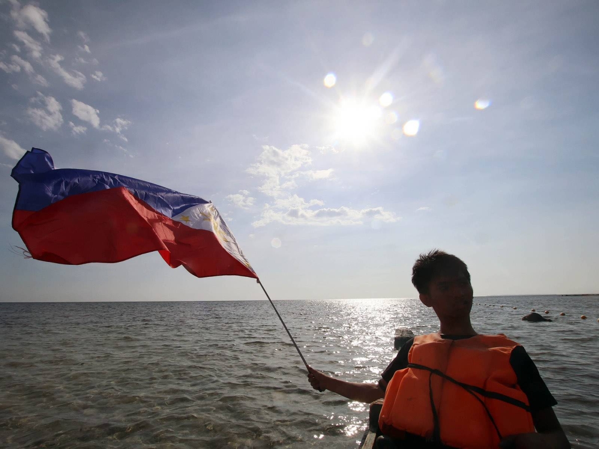 Fisherfolk from Zambales, along with Alyansa Bantay Kapayapaan at Demokrasya, wave a Philippine flag during a fluvial parade in the West Philippine Sea in Candelaria, Zambales, on Saturday, May 11, 2024, to express their condemnation of the harassment by the Chinese Coast Guard of Filipino fishermen. PHOTOS BY ISMAEL DE JUAN