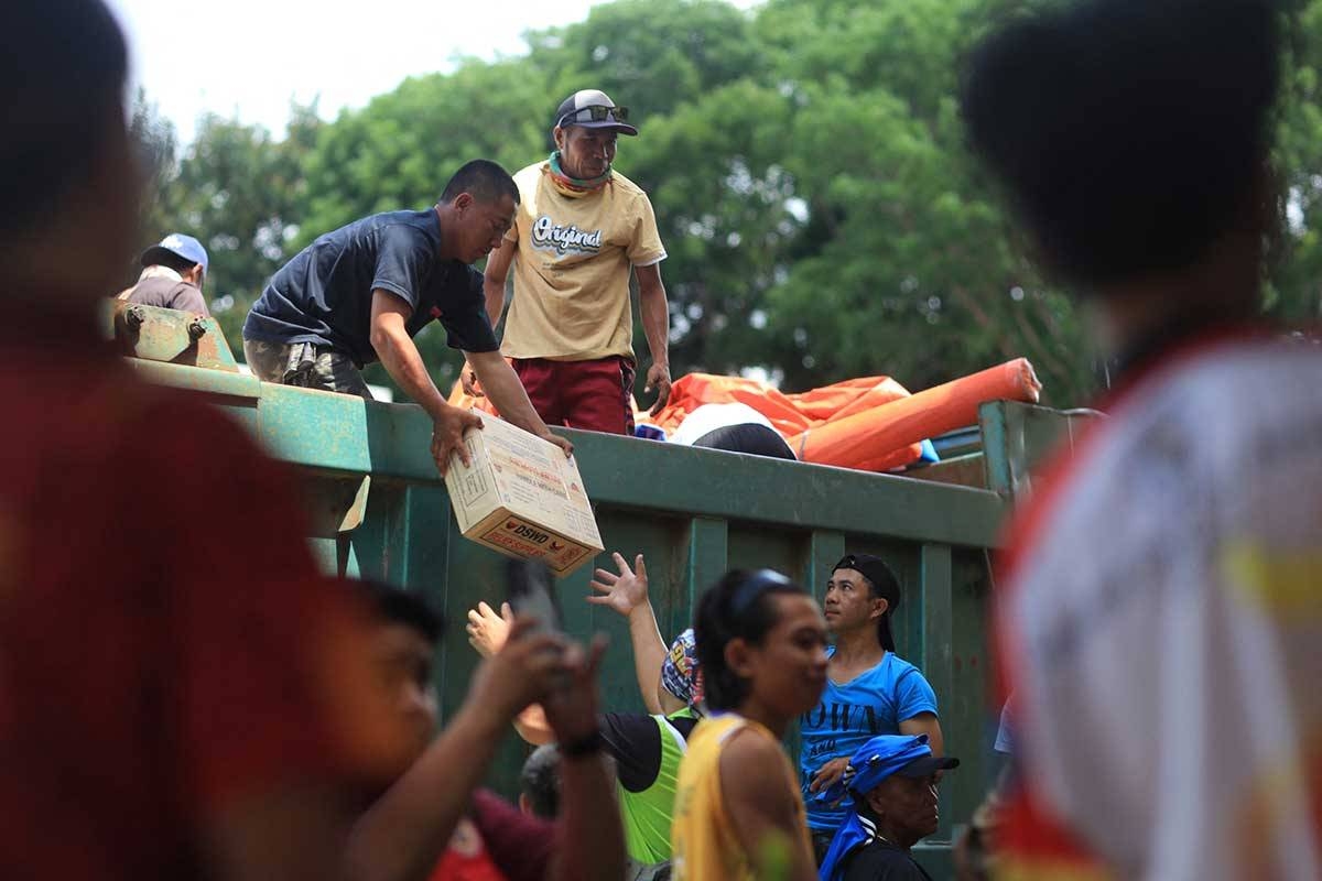 Workers unload relief food packs at an evacuation center set up at a school in a village in Canlaon City, Negros Occidental province, on June 4, 2024. AFP PHOTO