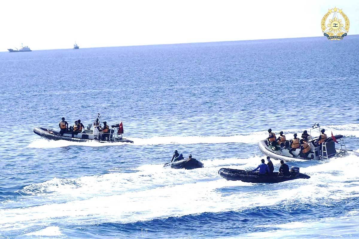 This handout photo taken on May 19, 2024 and received on June 4, 2024 from the Armed Forces of the Philippines shows two Chinese rigid-hulled inflatable boats (left and right) maneuvering close to Philippine personnel on board their boats (second left and second right) near the Philippine outpost at the Second Thomas Shoal in disputed waters of the South China Sea. AFP PHOTO